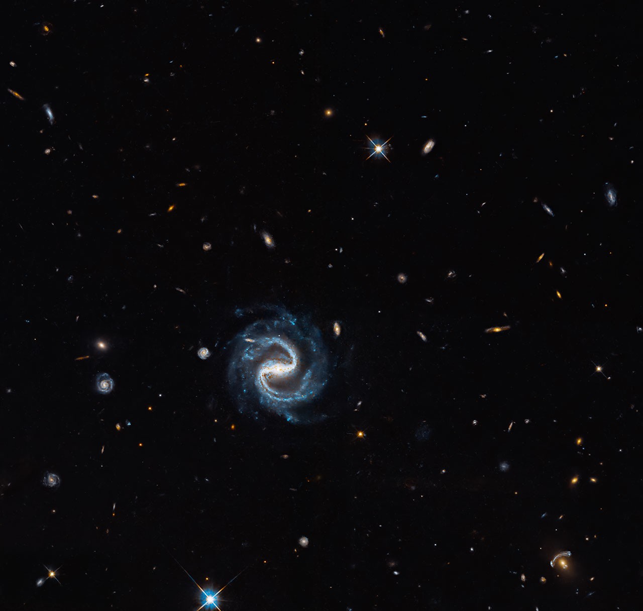 A spiral galaxy and a gravitational lens captured by the Hubble Space Telescope